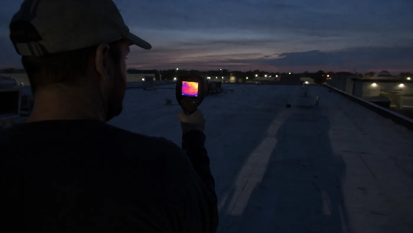 Infrared moisture survey being carried out at dusk on a Houston commercial roof
