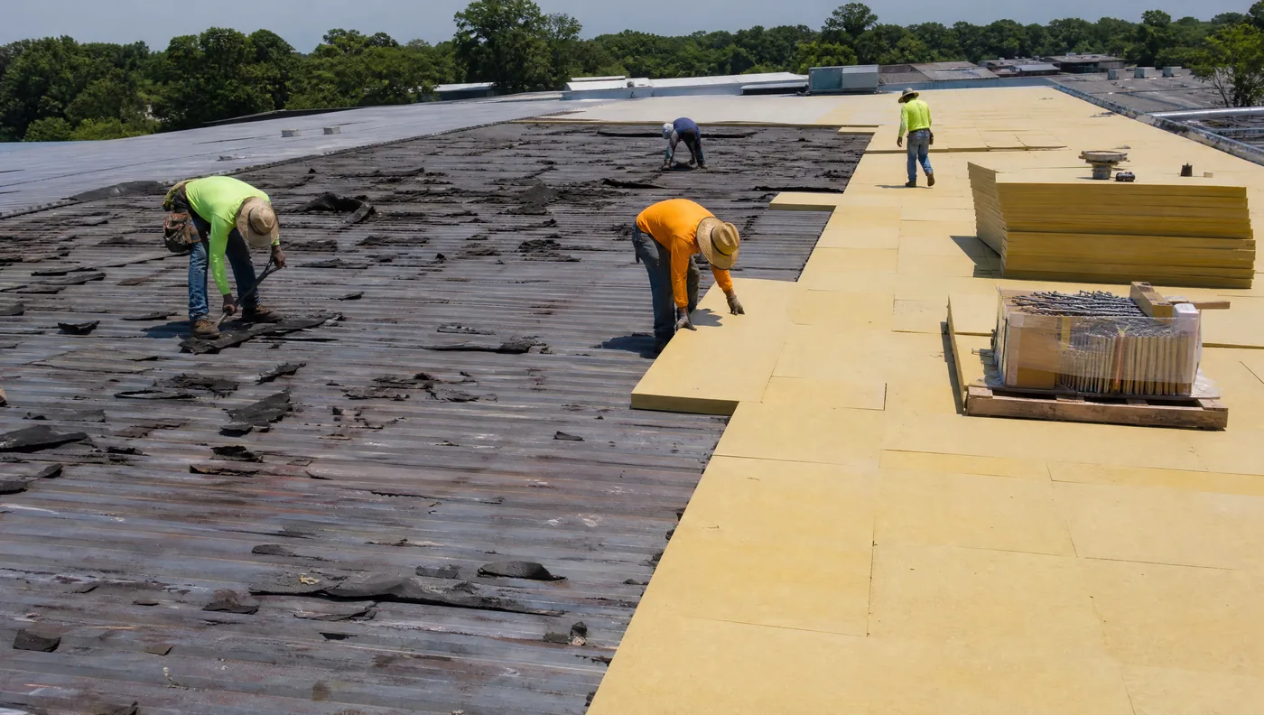 Tear-off and new polyiso being installed on a Houston commercial roof replacement