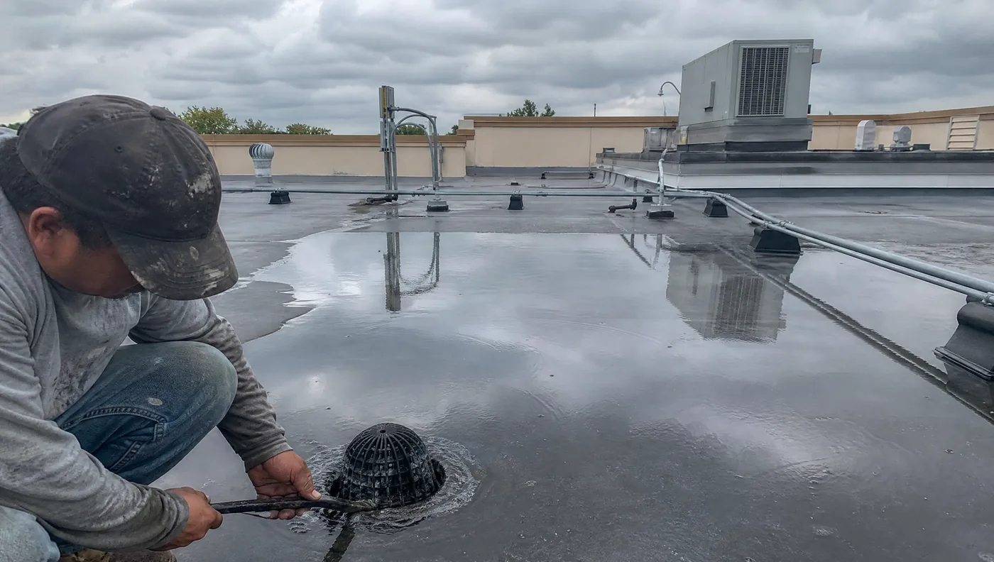 Low-slope commercial flat roof with roof drains and HVAC curbs in Houston